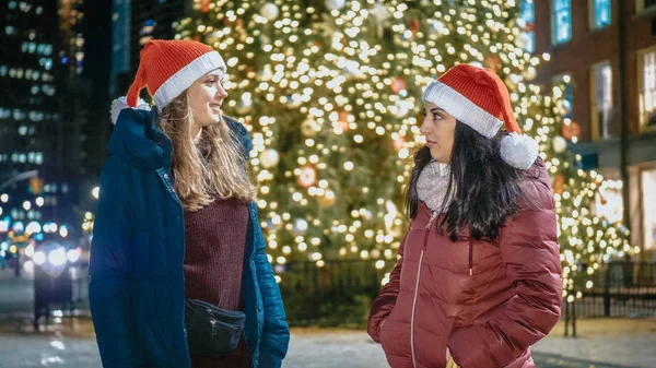 Two girls in front of a Christmas tree enjoy the wonderful time in New York — Stock Photo, Image