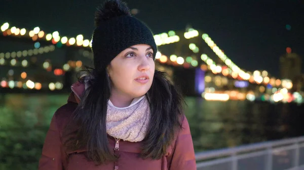 Junge Frau sitzt nachts an der Brooklyn Bridge in New York — Stockfoto