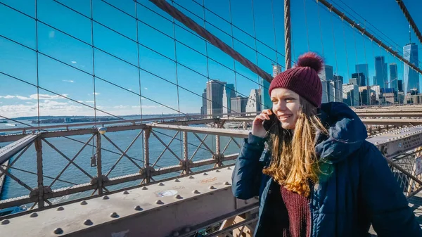 Ung vacker kvinna slappnar på Brooklyn Bridge medan du njuter av den fantastiska utsikten — Stockfoto