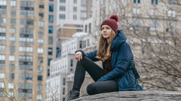 Une jeune femme se détend sur un rocher à Central Park New York — Photo