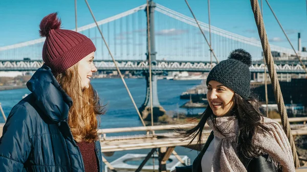 Zwei mädchen gehen über die berühmte brooklyn bridge in new york — Stockfoto