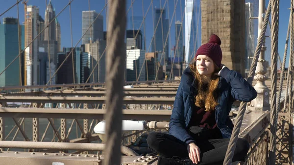 Belle fille sur Brooklyn Bridge bénéficie d'une journée ensoleillée tout en se relaxant — Photo