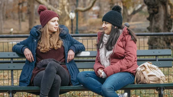 Due ragazze si siedono su una panchina di Central Park a godersi il loro tempo a New York — Foto Stock