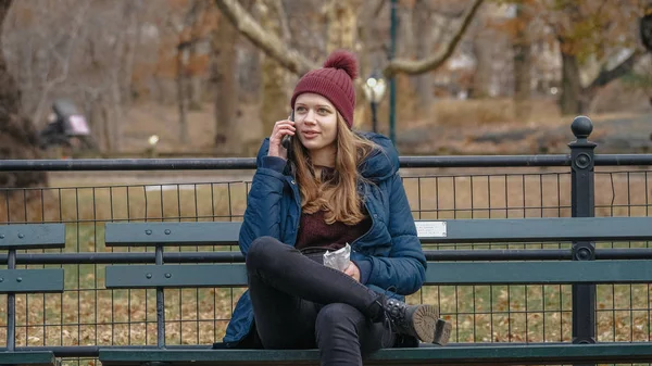 Junge Frau sitzt auf einer Bank im Central Park New York — Stockfoto