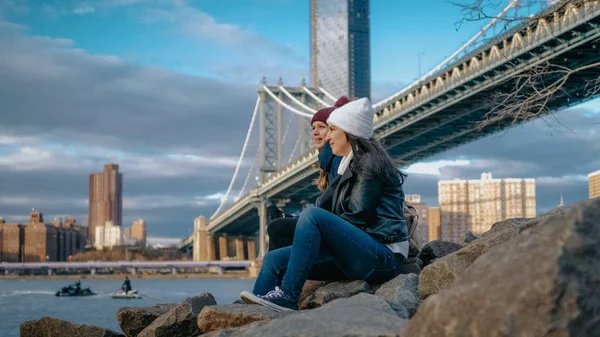二人の女の子がマンハッタン橋に座るし、ニューヨークへの観光旅行をお楽しみください。 — ストック写真