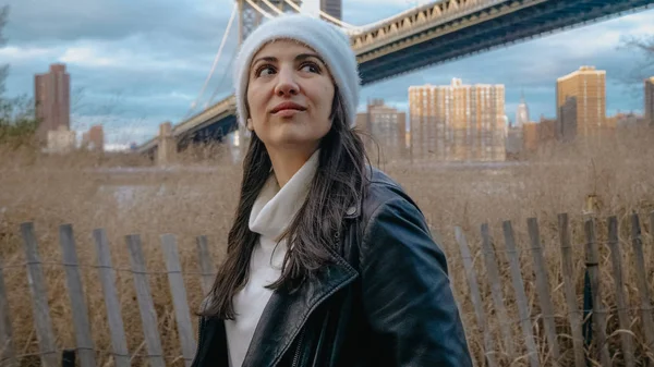 Junge frau spaziert entlang hudson river an der brooklyn bridge new york — Stockfoto