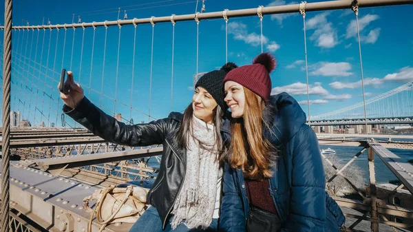Две молодые женщины делают селфи на Бруклинском мосту в Нью-Йорке — стоковое фото