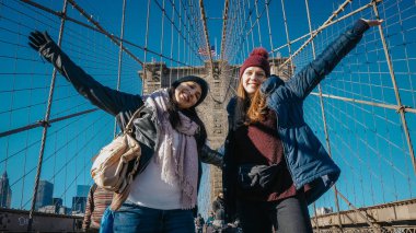 İki kız New York'ta ünlü Brooklyn Köprüsü üzerinde yürümek