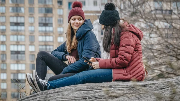 Two girls sit on a rock in Central Park New York — Stock Photo, Image