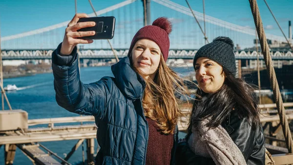 Dos amigos en Nueva York caminan por el famoso puente de Brooklyn — Foto de Stock