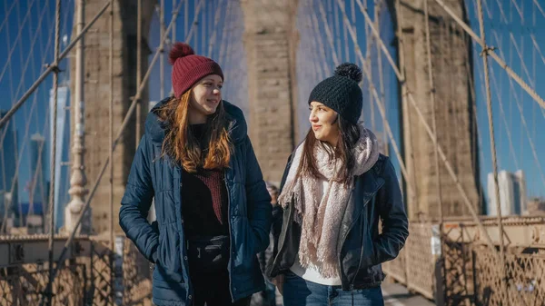 Två flickor gå över de berömda Brooklyn Bridge i New York — Stockfoto