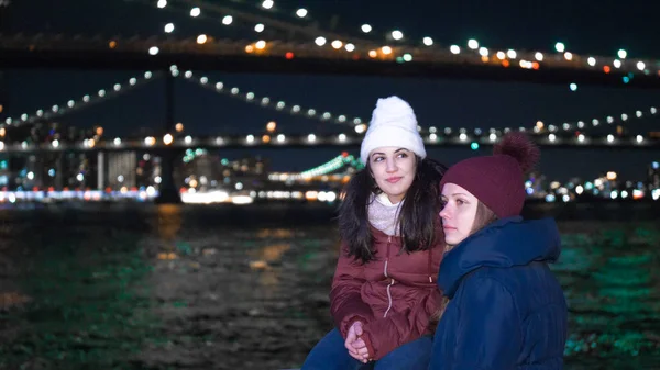 Dvě dívky prozkoumat New York v noci zde na Brooklynský most — Stock fotografie
