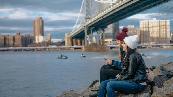 Dos chicas se sientan en Manhattan Bridge y disfrutan de su viaje a Nueva York — Foto de Stock