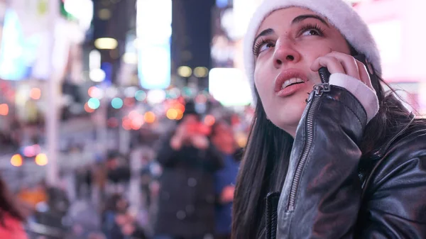Nuori nainen ottaa puhelun Times Squarella yöllä — kuvapankkivalokuva