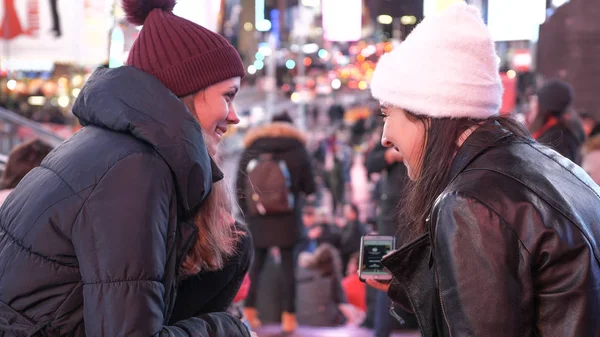 Two girls in New York enjoy the amazing view over Times Square by night — Stock Photo, Image