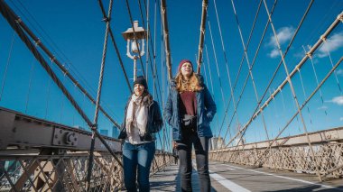 İki kız New York'ta ünlü Brooklyn Köprüsü üzerinde yürümek