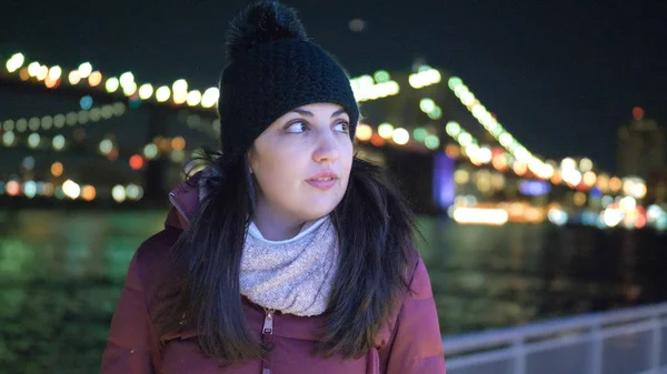 Ung kvinne sitter på Brooklyn Bridge New York om natten – stockfoto