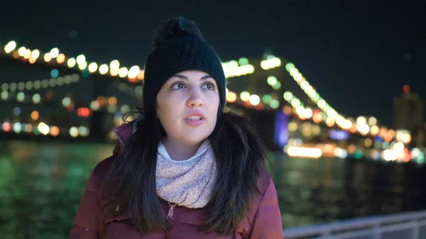 Mladá žena sedí na Brooklynský most v New Yorku v noci — Stock fotografie