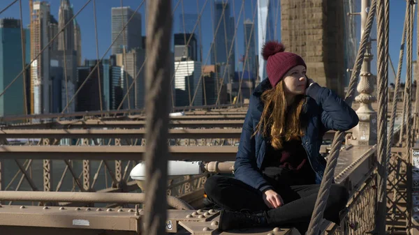 Beautiful girl on Brooklyn Bridge enjoys a sunny day while relaxing — Stock Photo, Image