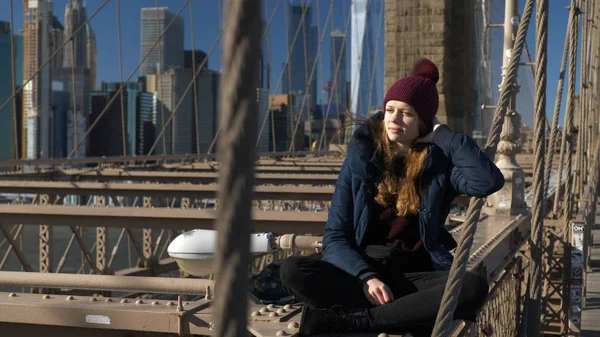 Menina bonita em Brooklyn Bridge goza de um dia ensolarado enquanto relaxa — Fotografia de Stock