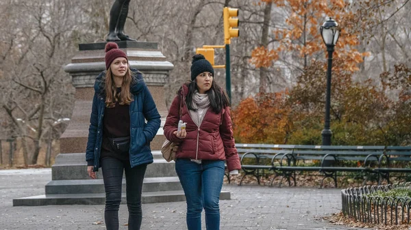 Две молодые женщины во время поездки в Нью-Йорк совершают расслабляющую прогулку в Центральном парке — стоковое фото