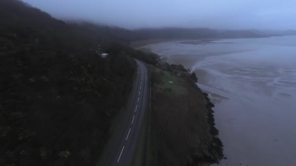 Conducir un coche en una pequeña carretera a la orilla del mar en la vista de la oscuridad desde arriba — Vídeos de Stock