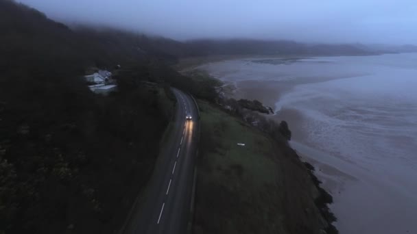 上から闇の眺めの海岸で小さな道路に車の運転 — ストック動画