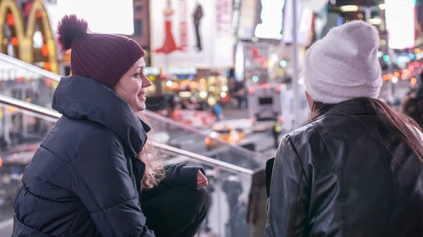 Zwei Mädchen in New York genießen den atemberaubenden Blick über den Times Square bei Nacht - New York, USA - 4. Dezember 2018 — Stockfoto