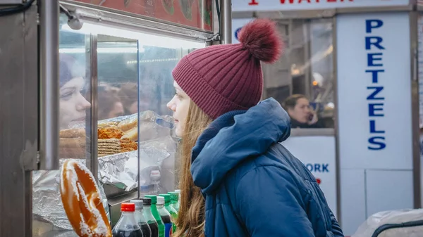 Девушка покупает хот-дог на улицах Нью-Йорка - НЬЮ-ЙОРК, США - 4 ДЕКАБРЯ 2018 — стоковое фото