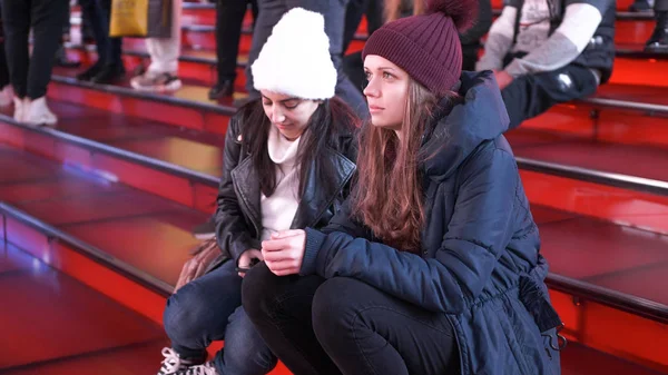 Due ragazze a Times Square di notte si siedono sui famosi gradini rossi - NEW YORK, USA - 4 DICEMBRE 2018 — Foto Stock