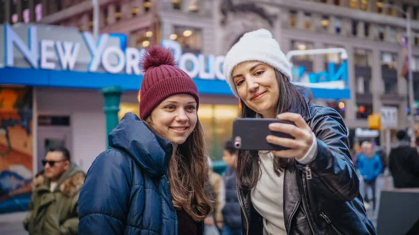 Two friends at Times Square enjoy their vacation trip to New York - NEW YORK, USA - DECEMBER 4, 2018 — Stock Photo, Image