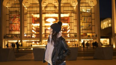 Genç kadın, Lincoln Merkezi New York önümde duruyor