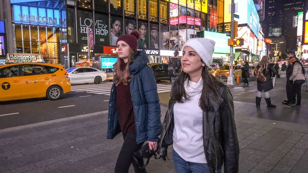 Young women walk at Times Square Manhattan by night - NEW YORK - — Stock Photo, Image