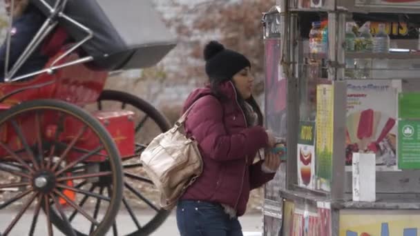 Una joven compra un perrito caliente en las calles de Nueva York — Vídeos de Stock