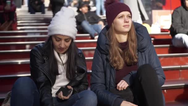 Young women sit on the famous Father Duffy steps at Times Square — Stock Video