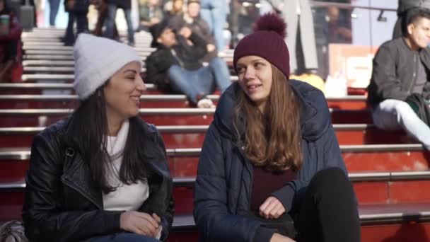 Young women sit on the famous Father Duffy steps at Times Square — Stock Video