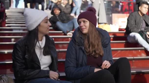 Les jeunes femmes s'assoient sur les célèbres marches du Père Duffy à Times Square — Video