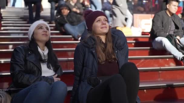 Молоді жінки сидять на сходах знаменитий батько Даффі іноді квадрат — стокове відео