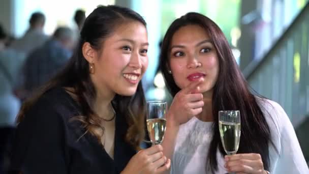 Сцена празднования - две девушки пьют шампанское и общаются на вечеринке — стоковое видео