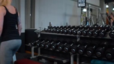 Genç kız bir spor salonu - fitness video klip egzersiz için barbell alır