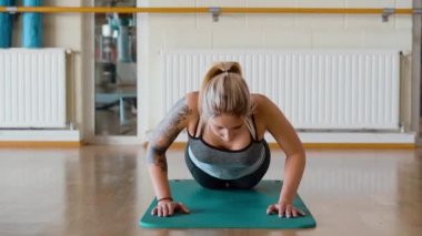 Spor salonunda şınav çeken genç bir kız.