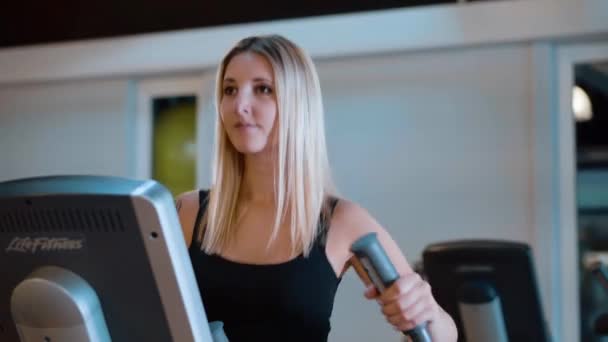 Jung und sexy mädchen ist running auf ein stepper im die fitnessstudio — Stockvideo