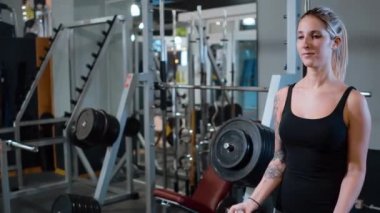 Spor salonunda genç ve seksi bir kız - halter eğitimi