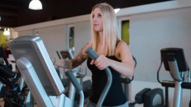 Genç ve seksi kız spor salonunda koşuyor.