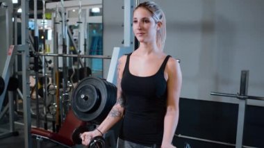 Spor salonunda genç ve seksi bir kız - halter eğitimi
