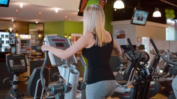 Jung und sexy mädchen ist running auf ein stepper im die fitnessstudio — Stockvideo