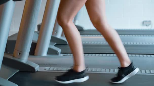 女孩在体育馆里的跑步机上跑步 — 图库视频影像