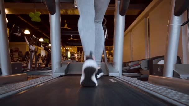 Flickan springer på ett löpband i gymmet — Stockvideo