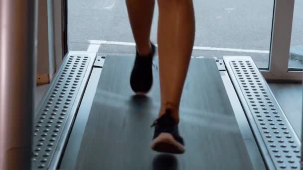 Fille court sur un tapis roulant dans la salle de gym — Video