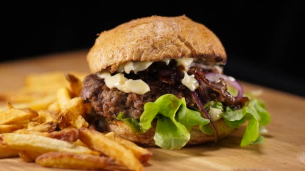 Comida rápida - Hamburguesa americana a la parrilla con papas fritas — Vídeos de Stock